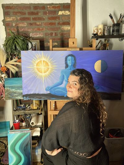 Artist Kathryn Denham sitting in front of her newest addition to the Blue Goddess Collection.